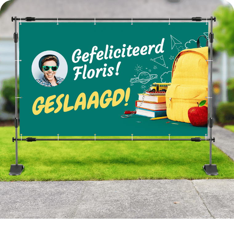 Groen spandoek met tekst ‘Gefeliciteerd Floris! Geslaagd!’, foto van jongen en schoolspullen.