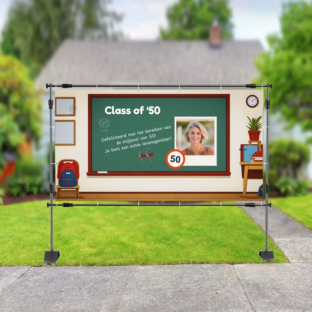 Verjaardagsspandoek in klaslokaalthema met schoolbord, tekst 'Class of ‘50', foto van vrouw, schoolitems en tekst 'Gefeliciteerd met het bereiken van de mijlpaal van 50! Je bent een echte levensgenieter!'