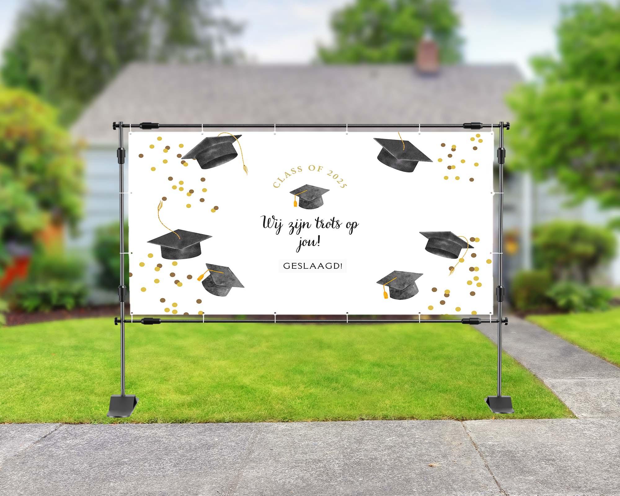Spandoek met witte achtergrond en de tekst 'wij zijn trots op je!' met afstudeerhoedjes erbij.