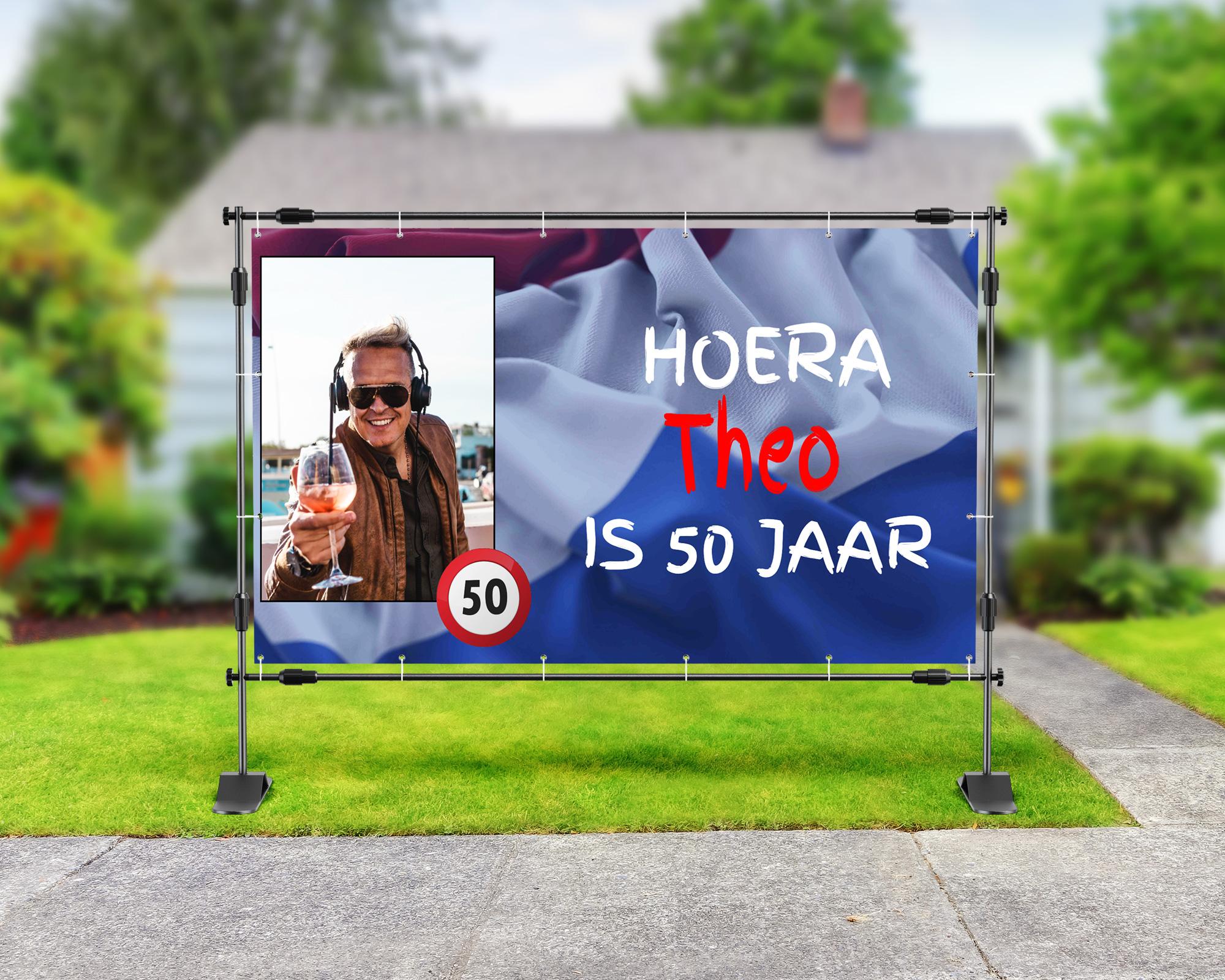 Spandoek Abraham 50 jaar met tekst 'Hoera Theo is 50 jaar', foto van Theo met een glas wijn, Nederlandse vlag en verkeersbord 50
