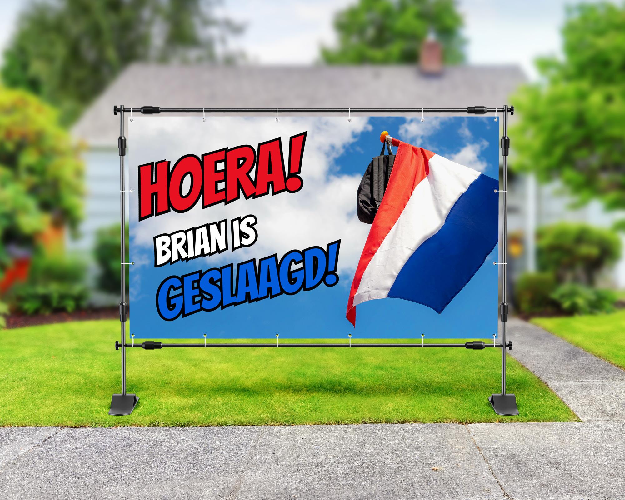 Spandoek geslaagd met tekst ‘Hoera! Brian is geslaagd!’, een Nederlandse vlag met schooltas en een blauwe lucht met wolken op de achtergrond.