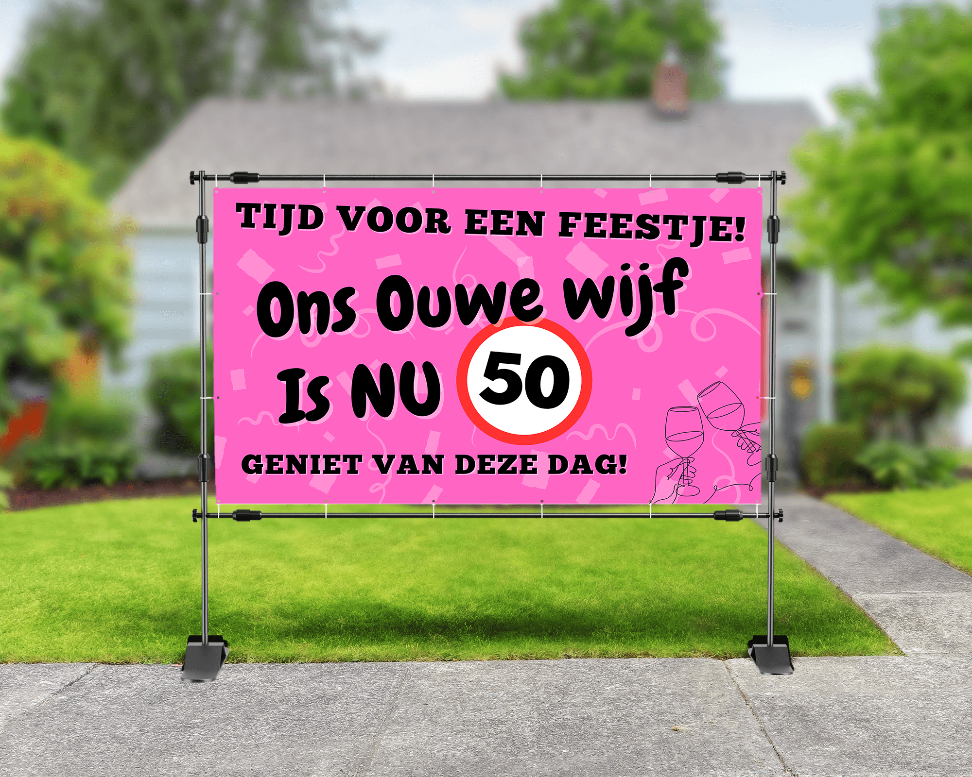 Spandoek voor 50e verjaardag met tekst ‘Dit ouwe wijf is nu 50’, foto van jarige vrouw, roze achtergrond met confetti en wijnglazen