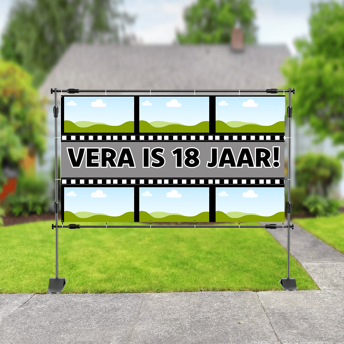 Spandoek in tuin met filmstrip-ontwerp en landschapsachtergrond, met in het midden de tekst: 'Vera is 18 jaar'