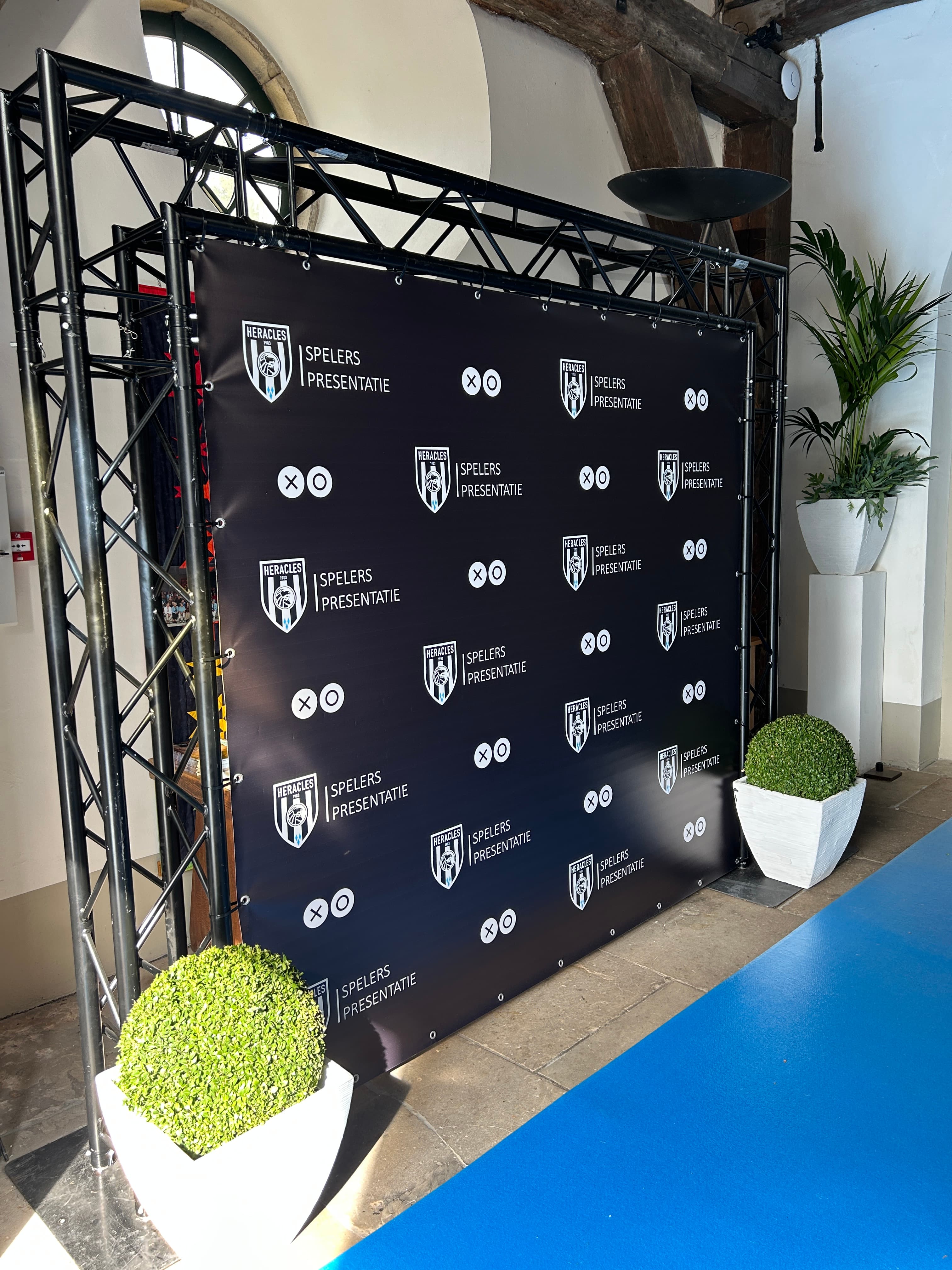 Zwart bedrukt evenementenspandoek met bedrijfslogo's bij een evenement